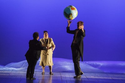Imatge on es veuen 3 persones passant-se una pilota inflable amb forma de Globus terraqüi.