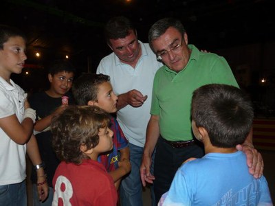Àngel Ros i el president de l'AAVV de veïns de la partida de Torres de Sanui, parlant amb uns nens.