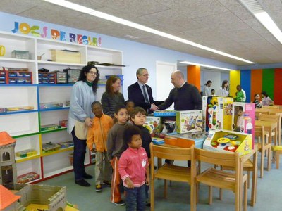 El regidor d'Educació saluda el representant de Calucho, al costat dels infants i una educadora de la ludoteca..