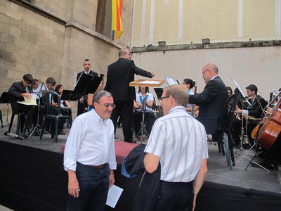 Foto 2. Àngel Ros ha saludat el director de la Banda, Amadeu Urrea, abans de començar el concert.