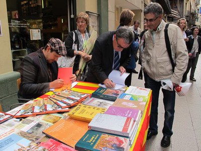 Foto 2. L'alcalde, signant el seu llibre "Lleida, la força de la nova Catalunya”, que també s'ha pogut trobar a les parades de llibres.