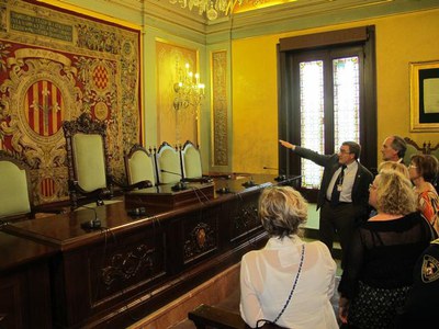 Foto 4. Àngel Ros, en la visita al Saló de Plens, mostrant el retaule amb la crònica de Ramon Muntaner.