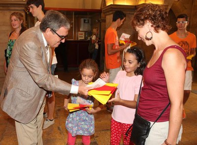 Nombrosos lleidatans i lleidatanes s'han atansat al pati del Palau de la Paeria a recollir la senyera aquest matí..