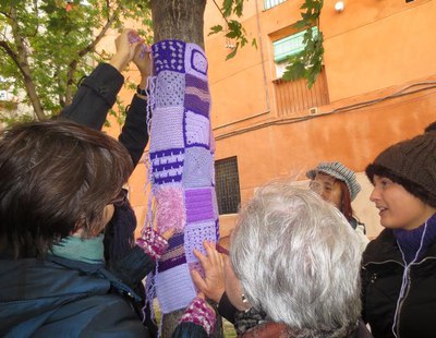 Acció urbana amb labors de color lila contra la violència masclista.
