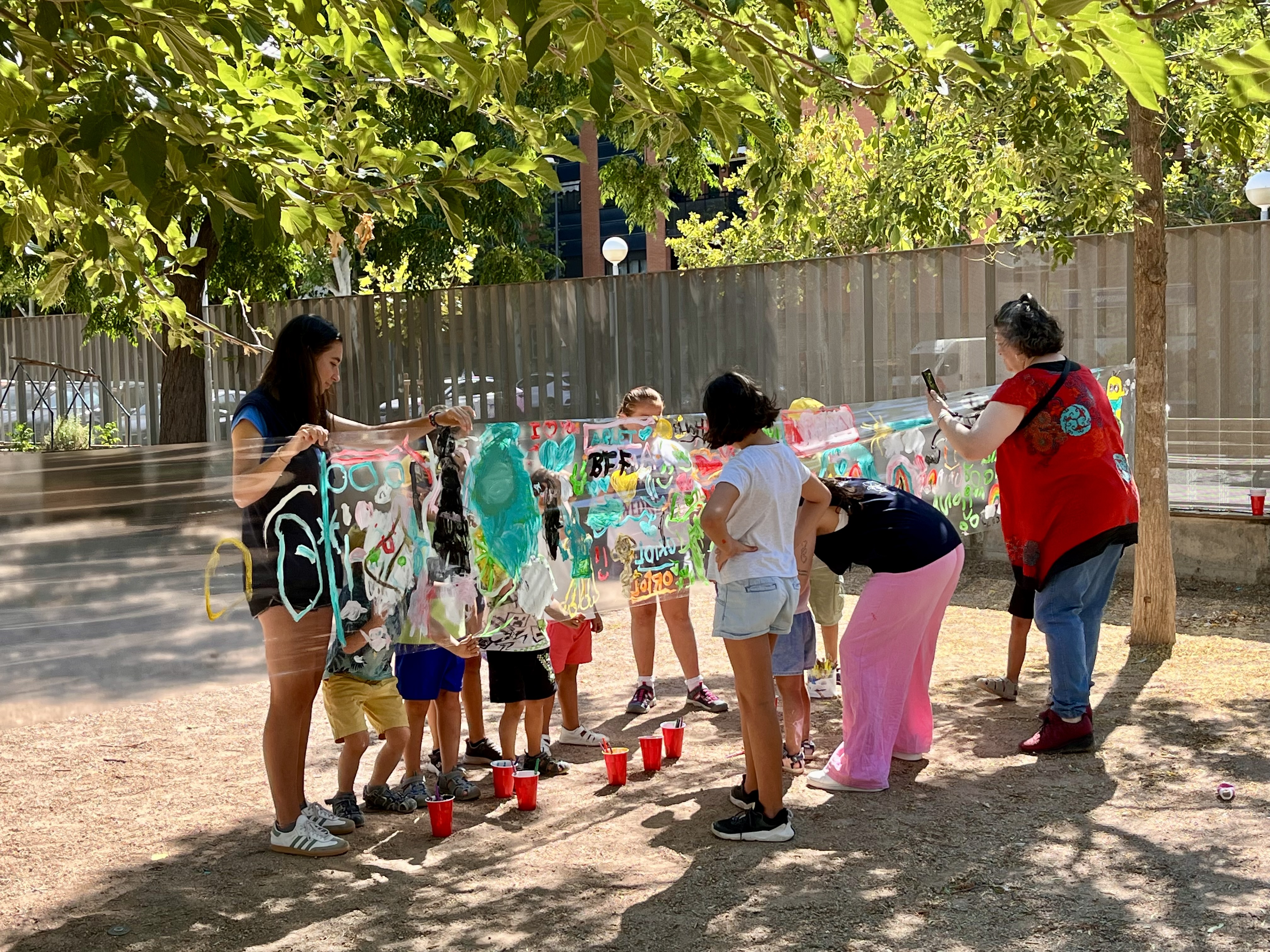 Infants i monitores en una de les activitats organitzades al pati de l'Escola La Mitjana