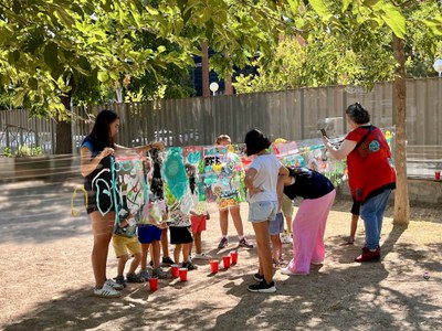 Infants i monitores en una de les activitats organitzades al pati de l'Escola La Mitjana.