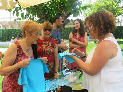 Els regidors Sara Mestres, Txema Alonso i Dolors Arderiu, comprant diversos productes de marxandatge en benefici de la Fundació Esclerosi Múltiple.