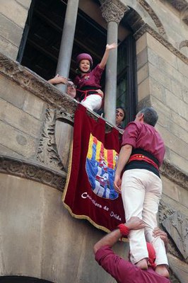 El paer en cap, agafant l'enxaneta del pilar de la colla local per la finestra de la Paeria.