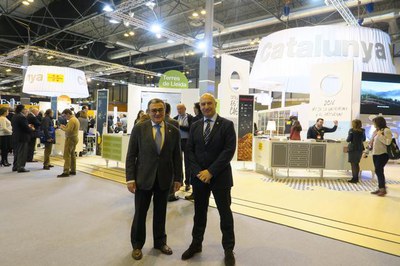 El paer en cap Àngel Ros i el tinent d'alcalde Rafel Peris, davant de l'estand de Catalunya de FItur..