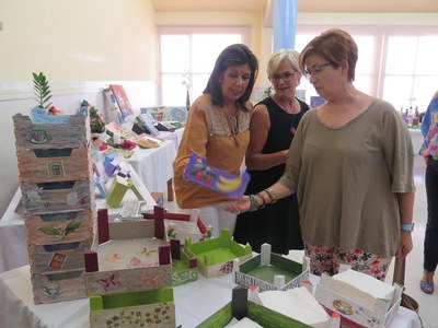 Montse Parra i Dolors López, visitant l'exposició de treballs manuals dins de la Setmana Cultural de l’AV Mariola.