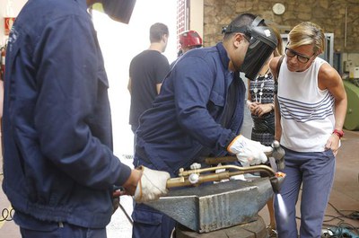 L'alcaldessa accidental, M.Mínguez, amb els joves alumnes de la Casa d’Oficis de l’IMO fabriquen la nova tanca del Castell de Templers.