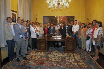 La pregonera, Mari Pau Huguet, signant al llibre d'Or de la ciutat acompanyada de la corporació municipal..