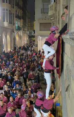 La tinent d'alcalde Montse Mínguez i el regidor Carles Vega, amb agafant els enxanetes dels Castellers de Lleida des de la finestra de la Paeria.