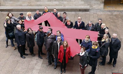 Els participants han desplegat un gran llaç vermell a la plaça.