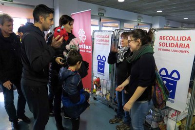 Recollida de joguines a l'entrada del pavelló amb els voluntaris de Càritas.