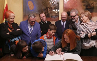 La codirectora de la Fira, Elisabet Vallvé, firmant al llibre d'honor de la Paeria.