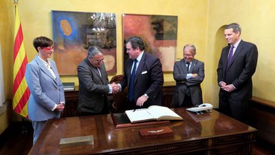 Àngel Ros i Richard Duke Buchan III fan una encaixada de mans després de la signatura de l'ambaixador al Llibre d'Honor.