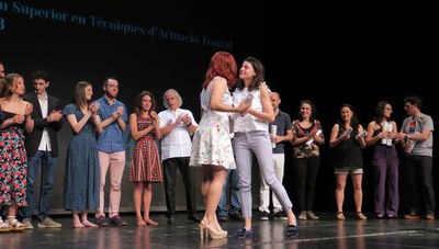 La regidora d'Educació lliurant una orla a una de les alumnes graduades.