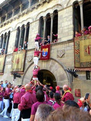 El paer en cap agafant l'enxaneta des de la finestra de la Paeria en finalitzar la diada.