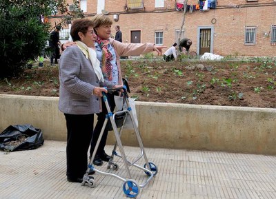 La tinent d'alcalde Sara Mestres, mostrant a una veïna del barri el treball dels voluntaris.