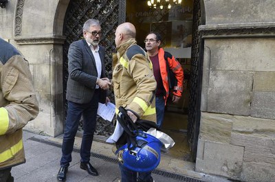 El paer en cap saluda un representant dels Bombers a la porta del Palau de la Paeria..