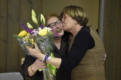 La tinent d'alcalde Sara Mestres saluda Dolors Flix després de donar-li un ram de flors.