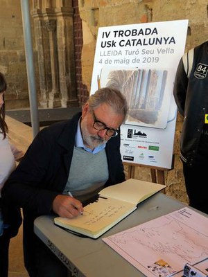 L'alcalde Larrosa, signant en el llibre de la trobada.