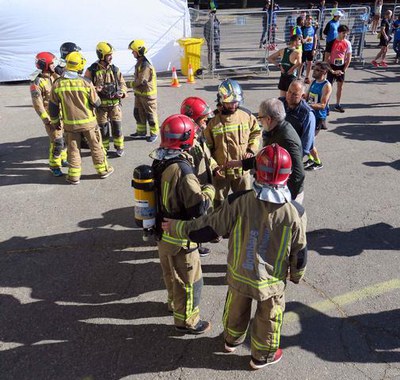 El paer en cap saludant els bombers que han fet la cursa amb l'equipament de feina.