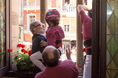 El paer en cap, Fèlix Larrosa, agafant 'enxaneta del pilar dels Castellers de Lleida per la finestra de la Paeria.
