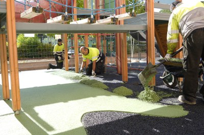 Els operaris estenent el nou paviment.