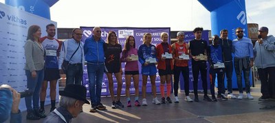 Podi conjunt dels primers classificats en la carrera de 10 km amb els regidors Amor i Melé i els organitzadors i patrocinadors.
