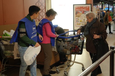Una clienta diposita la seva donació al Banc dels Aliments.