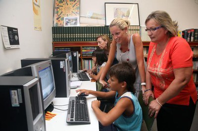 Montse Mínguez amb la presidenta de l'AV de Llívia i els primers usuaris del telecentre..