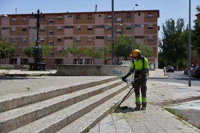 Desbrossament d'una vorera a la plaça Barcelona.