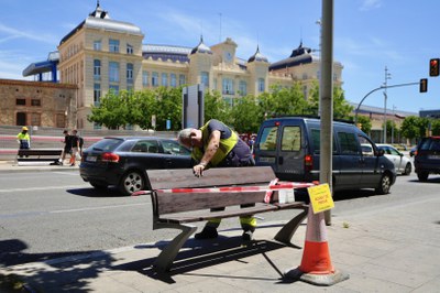 Tasques de repintat d'un banc a Príncep de Viana.