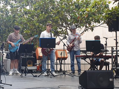 Tres joves tocant música moderna a l'escenari del C/Pi i Maragall.