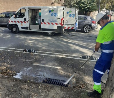 Un operari de la concessionària Aqualia netejant un embornal.