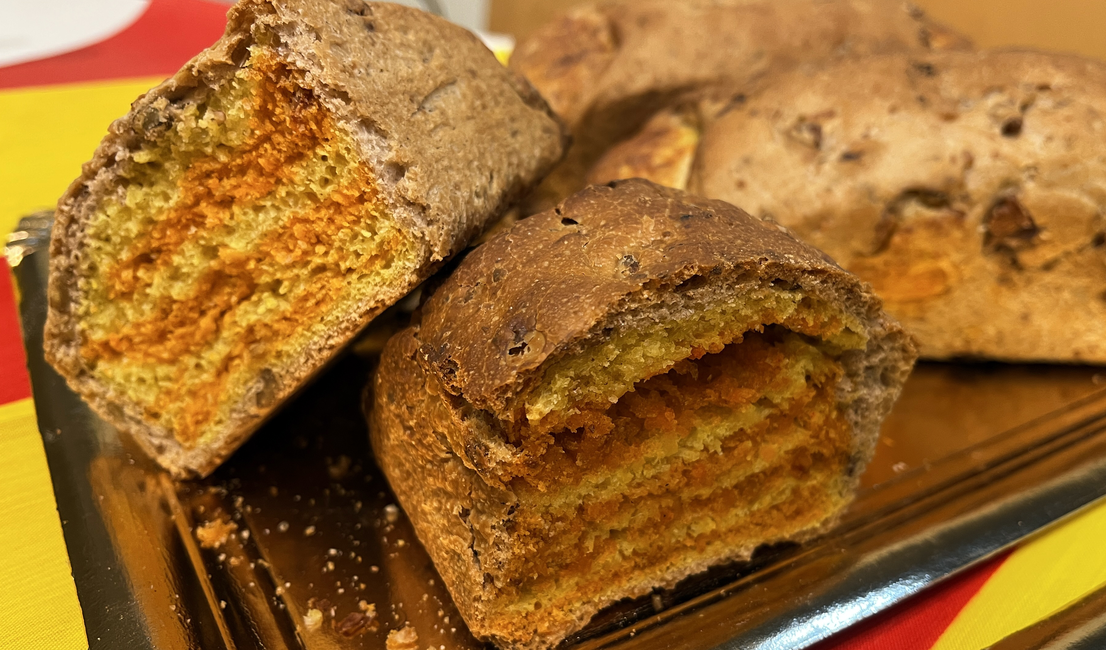El pa de Sant Jordi s'elabora amb sobrassada, formatge i nous, i mostra les quatre barres catalanes