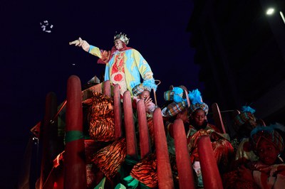 El rei Baltasar tira caramels al públic durant el recorregut.