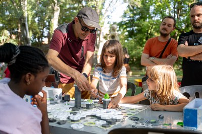 Infants i adults jugant a un joc d'enginy.