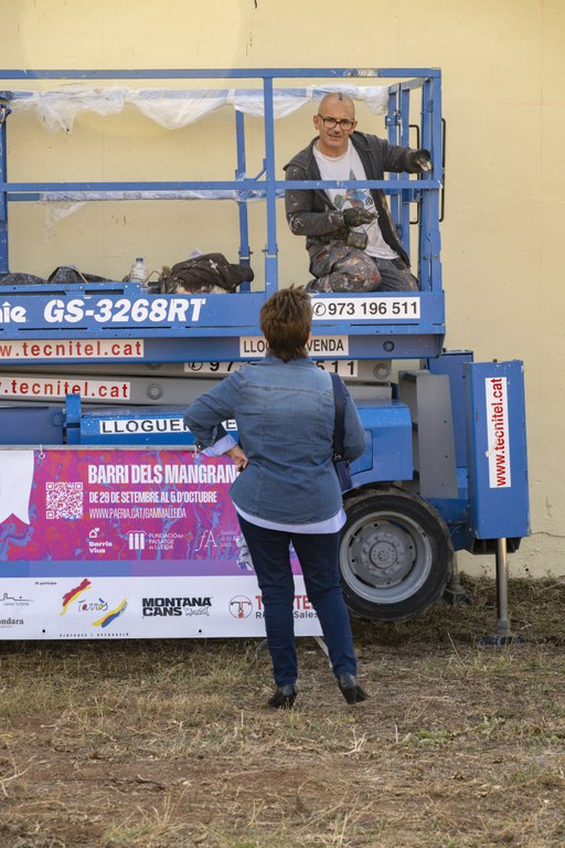 Una veïna parlant amb l'artista Roc BlackBlock