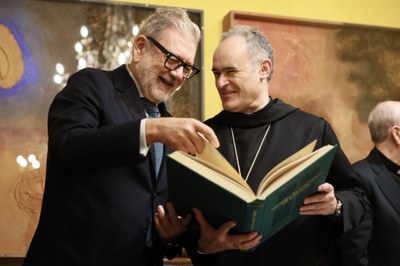 L'alcalde, Fèlix Larrosa, i l'Abat, P. Manel Gasch, fullegen el Llibre dels Usatges.