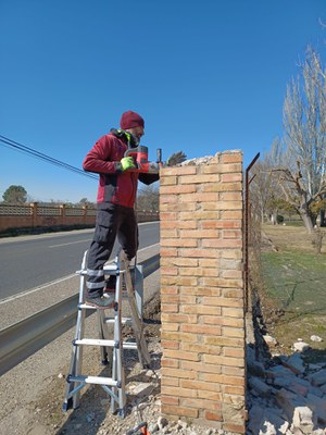 Un operari repara la tanca que envolta el parc de Les Basses.