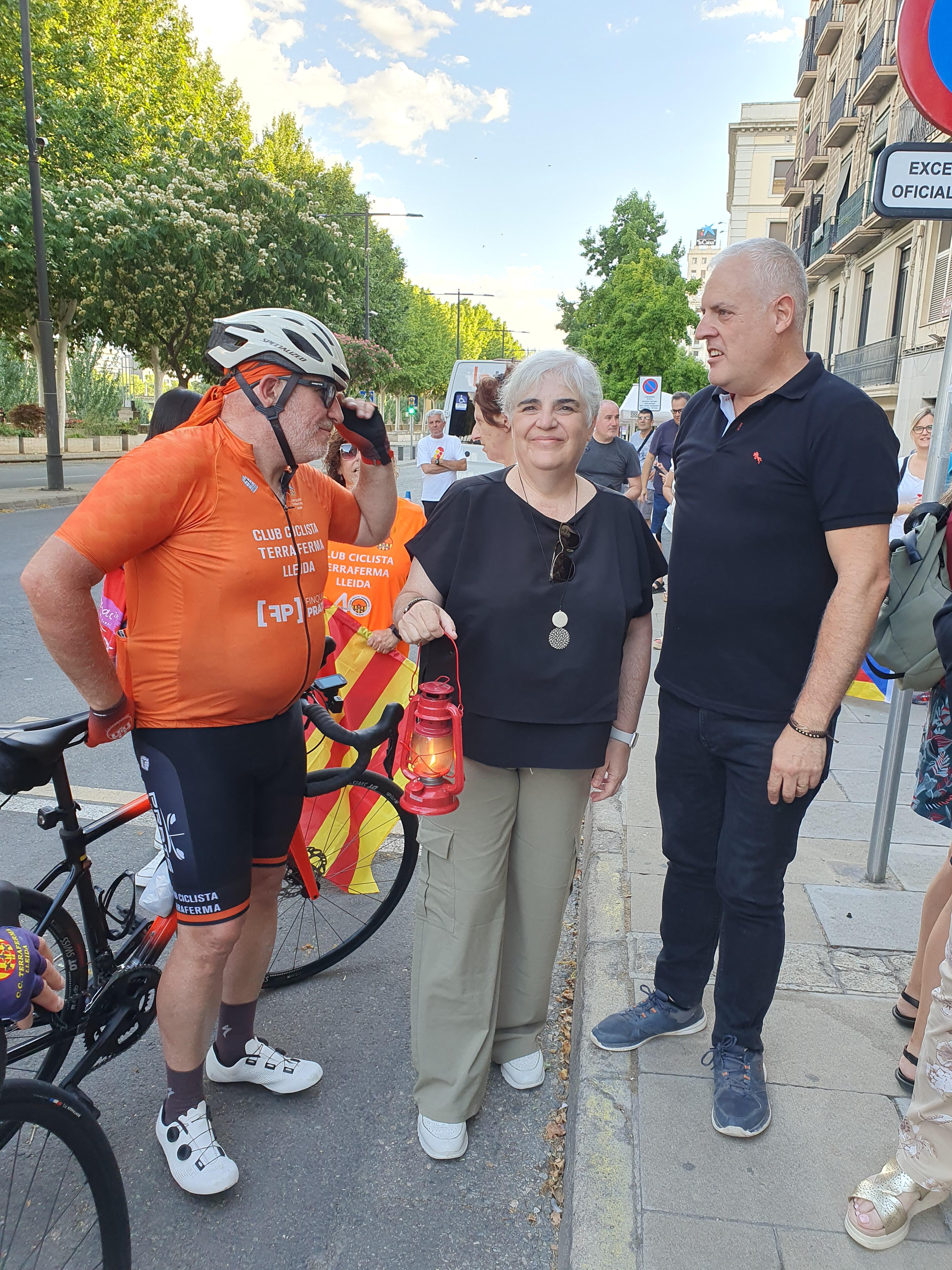 La tinent d'alcalde, Carme Valls, rebent la Flama per part d'un dels ciclistes