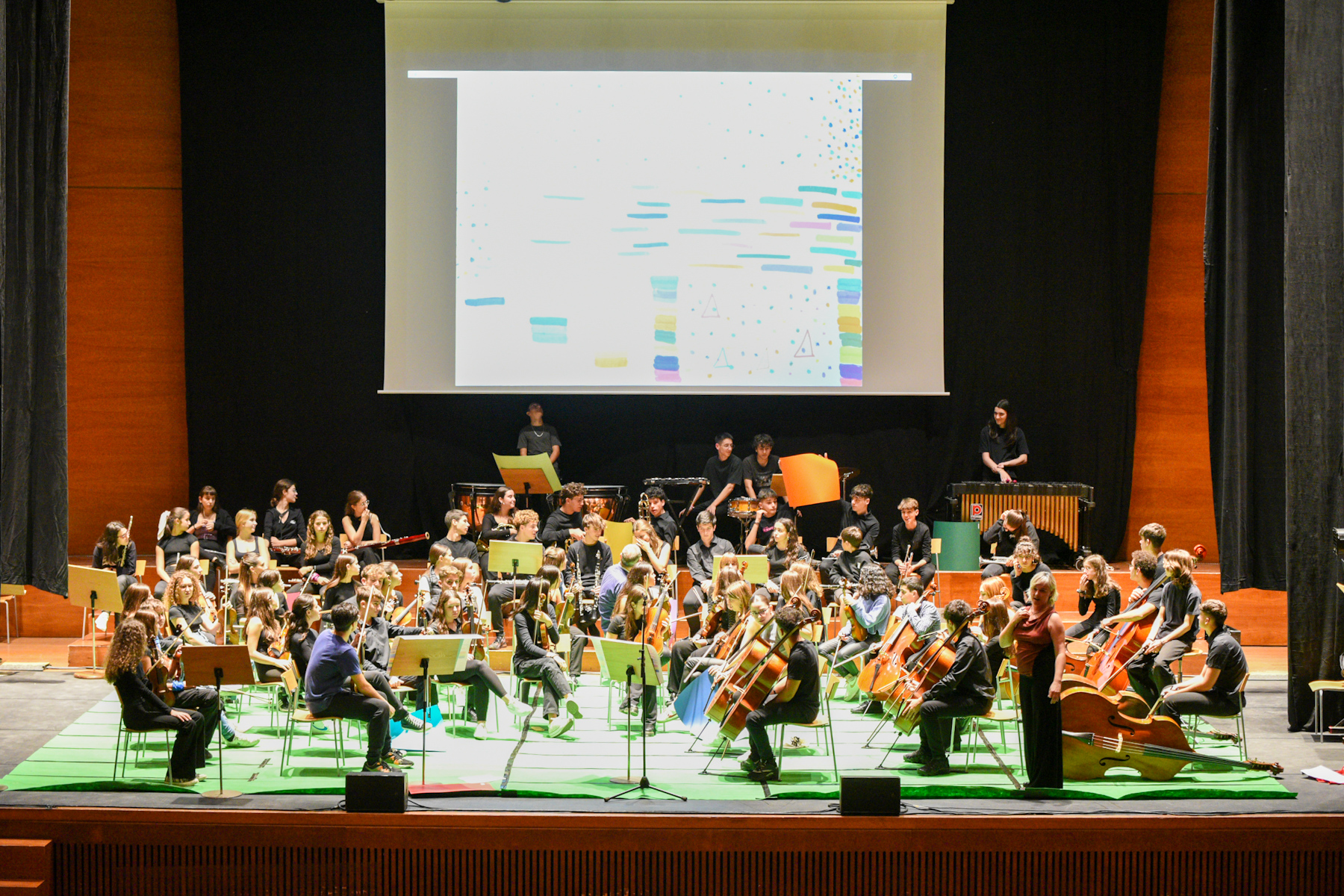 Interpretació a l’Auditori municipal Enric Granados de la percussionista Núria Andorrà, amb  77 alumnes de l’escola de música ‘l’Intèrpret’ i de l’Orquestra Simfònica del Conservatori. Peça de composició instantània utilitzant IA.