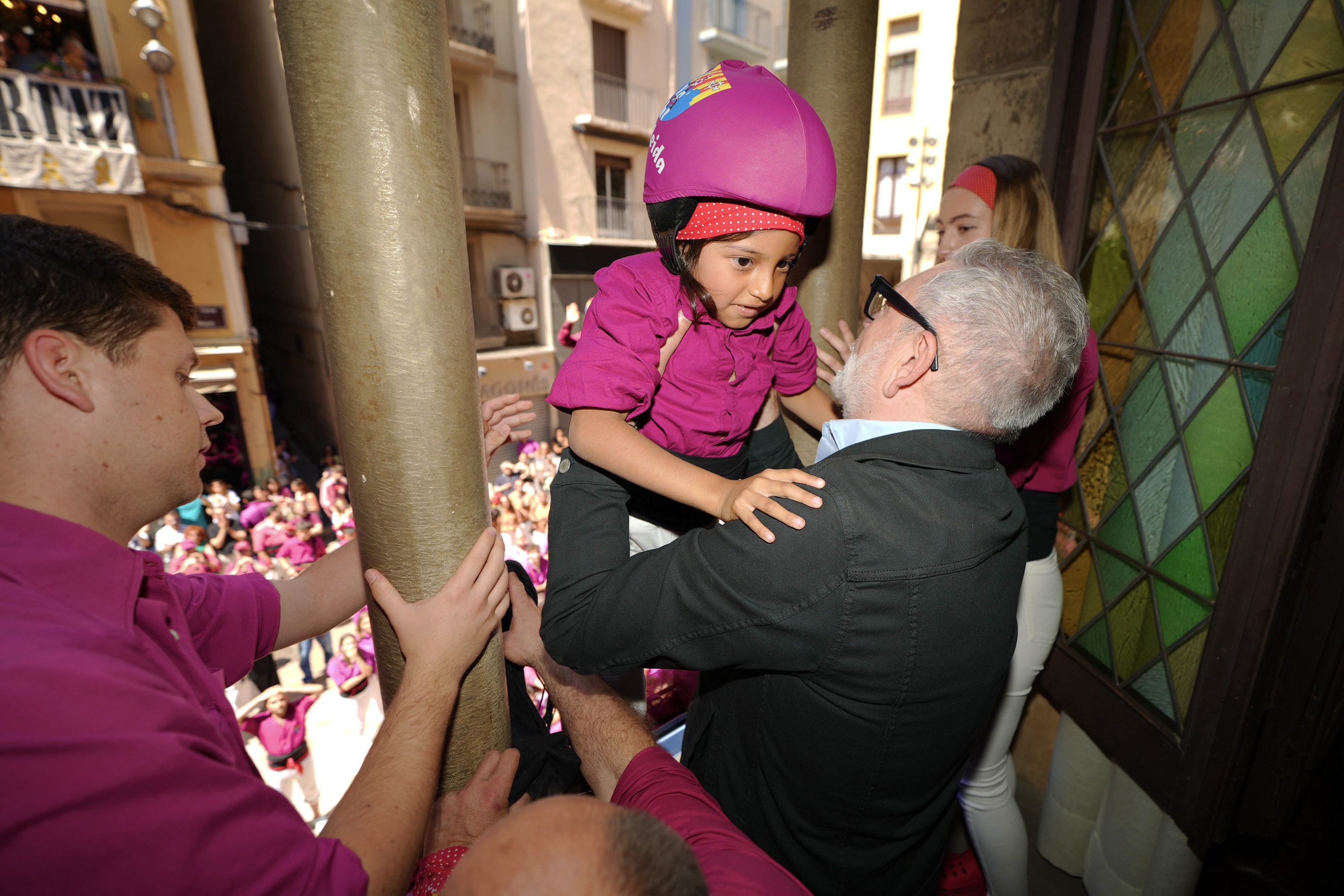 L'alcalde recull l'anxaneta dels Castellers de Lleida del pilar al balcó.