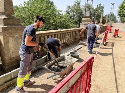 Operaris treballant en la millora del passeig de la Banqueta del riu Segre.