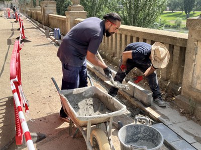 Operaris treballant en la millora del passeig de la Banqueta del riu Segre.