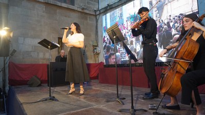 La cantant i els músics a l'escenari de la plaça de la Paeria.