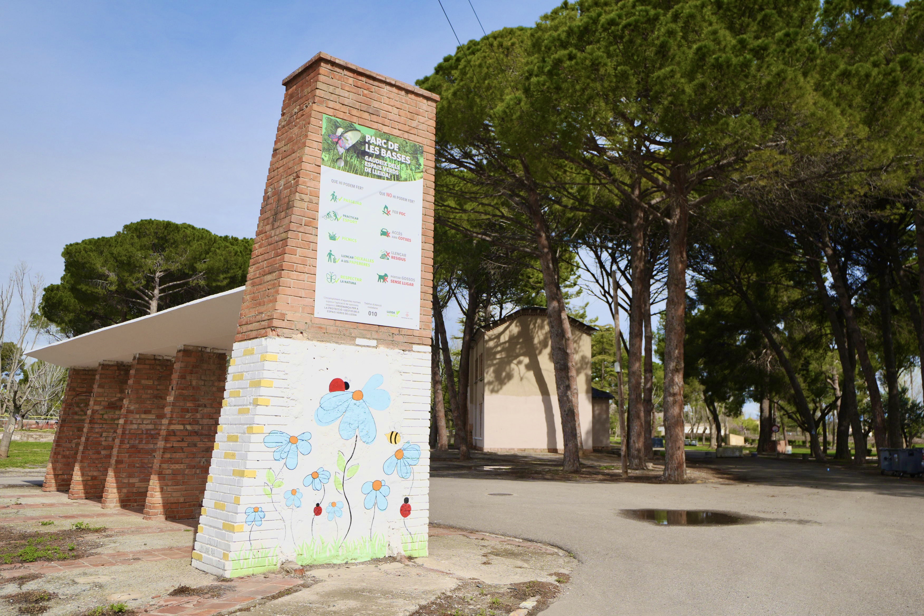 Imatge de l'accés al Parc de Les Basses, amb les normes d'ús del parc.